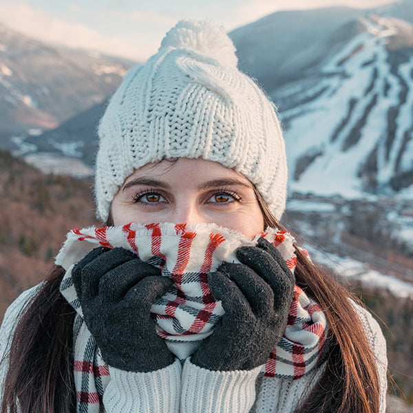 Woman in cold weather with hat and scarf in the mountains