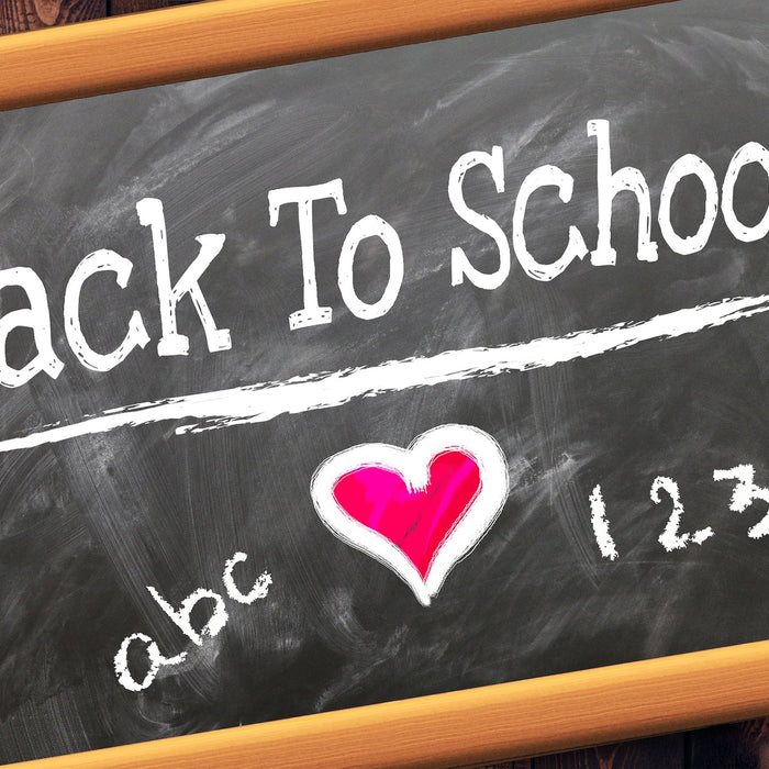 Black board reading back to school with a red heart in the middle