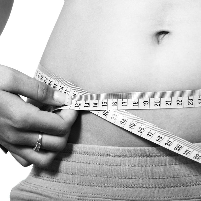 Woman measuring her belly