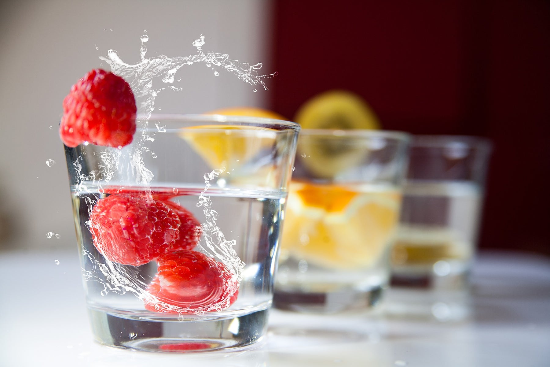 Raspberries dropped in a glass of water