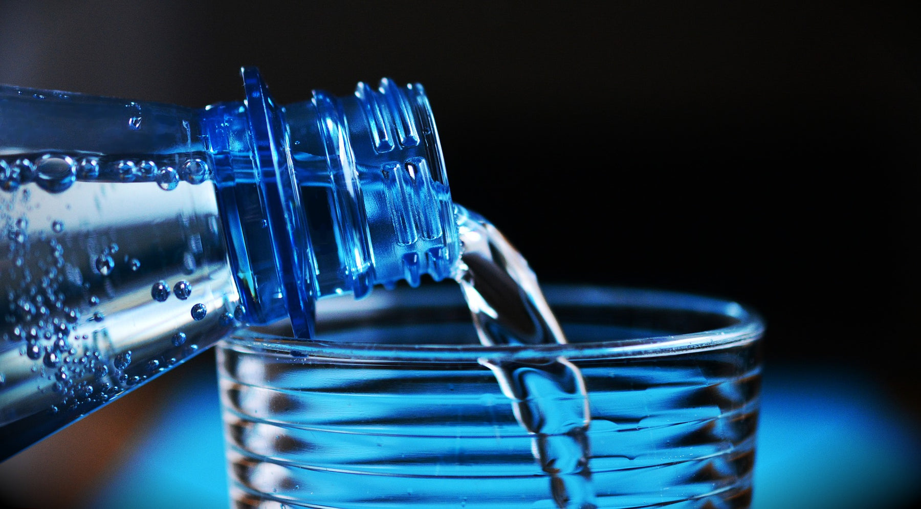 Bottle pouring water into a glass