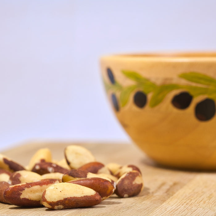 Brazilian nuts on a wooden table next to a bowl
