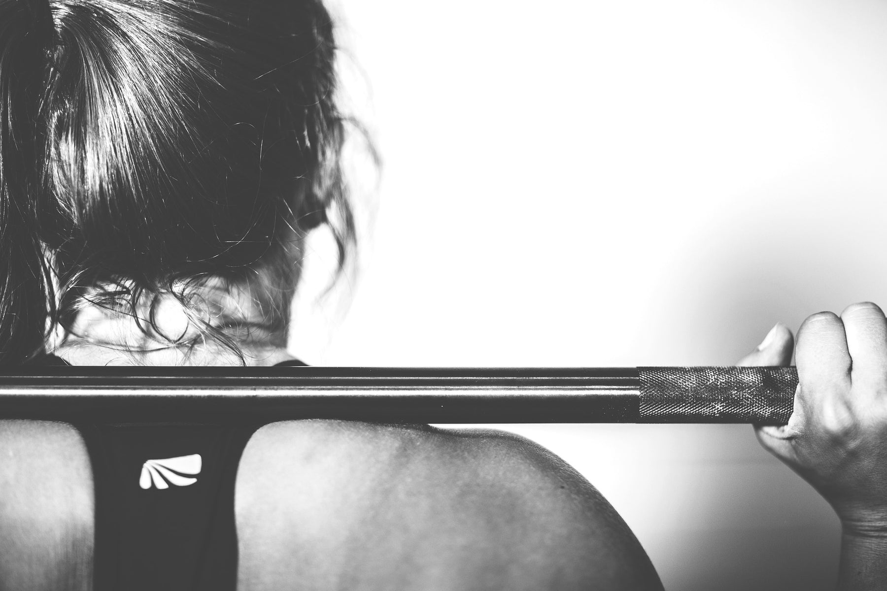 Woman holding barbell over the shoulders