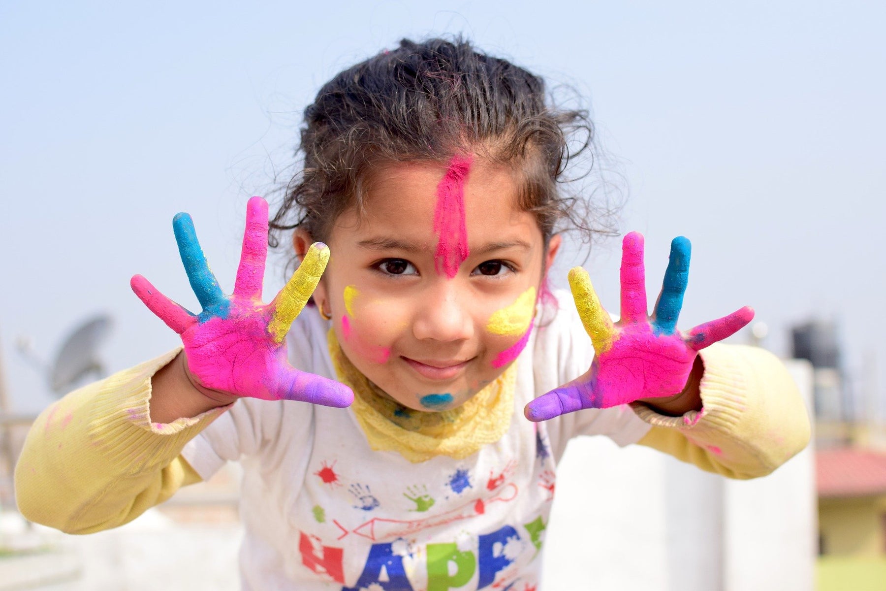 Smiling girl with hands full of colors