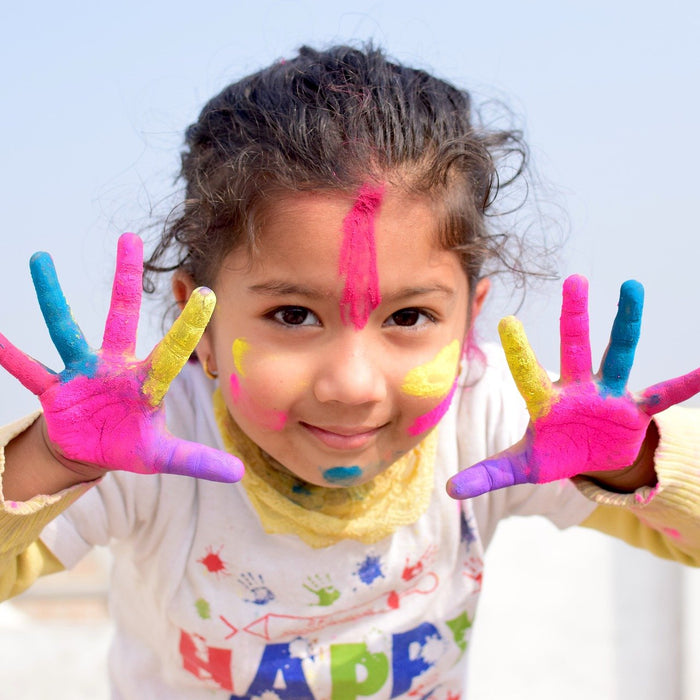 Smiling girl with hands full of colors
