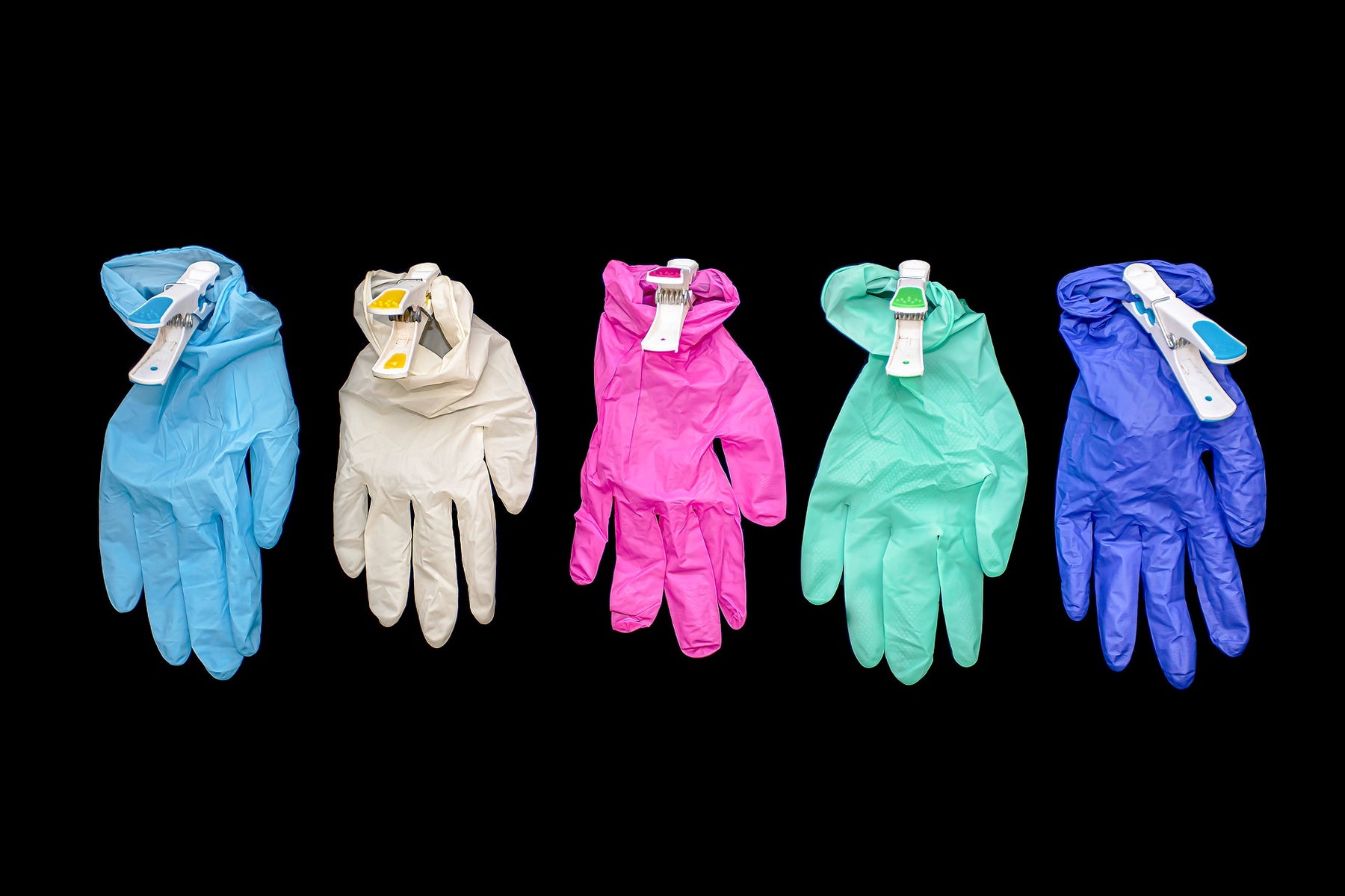 Five surgical gloves of different colors