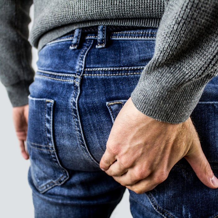Man in blue jeans having trouble with hemorrhoids