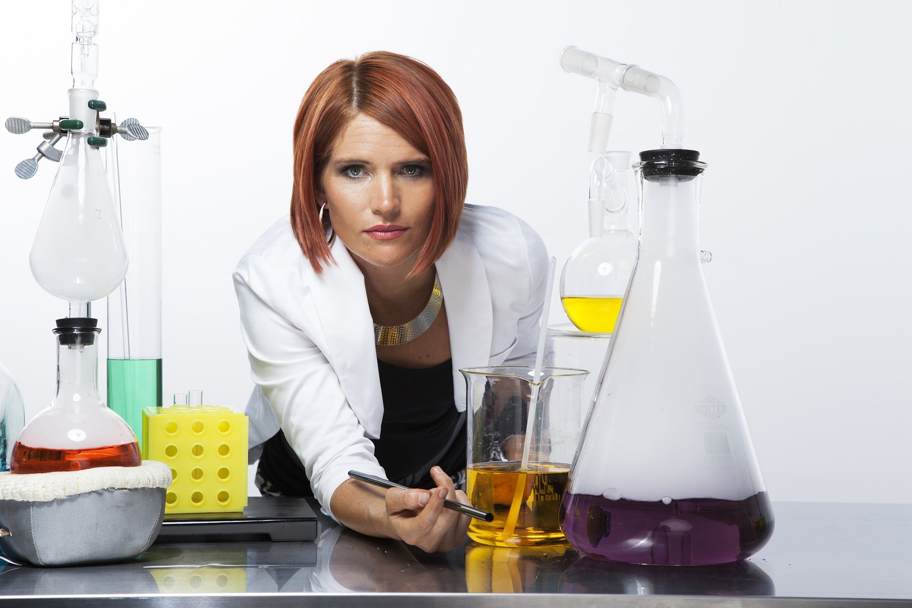Woman surrounded by laboratory glasses looking at the camera