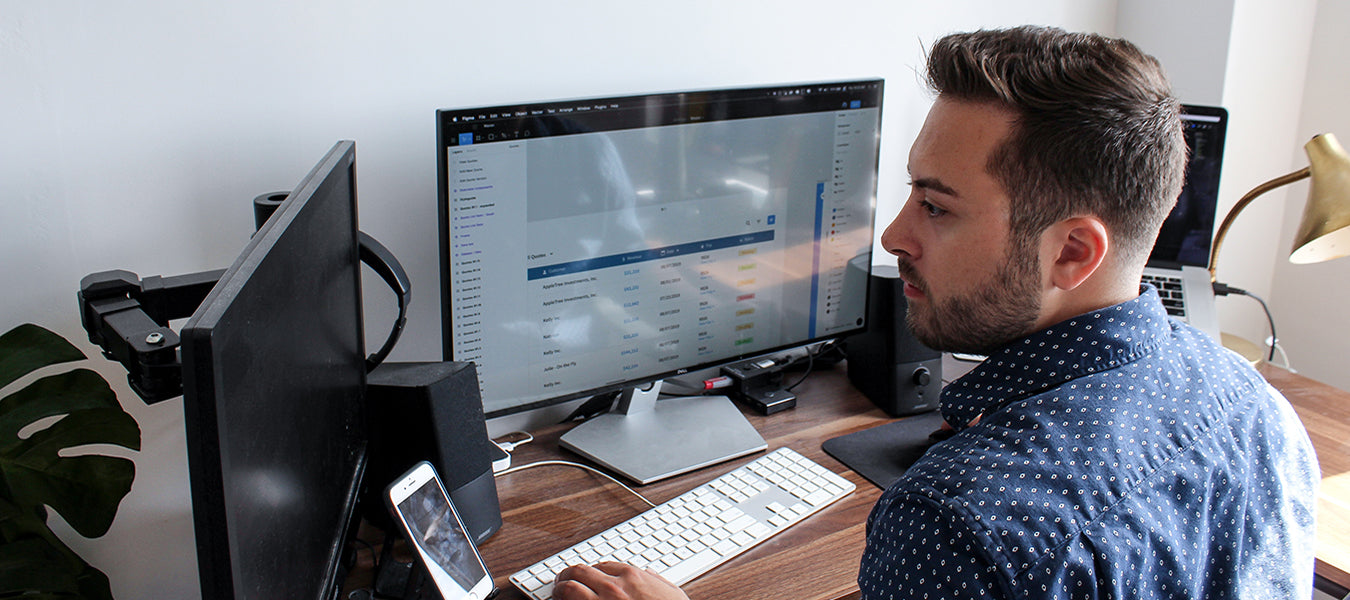 Man working with two monitors and one phone at the same time