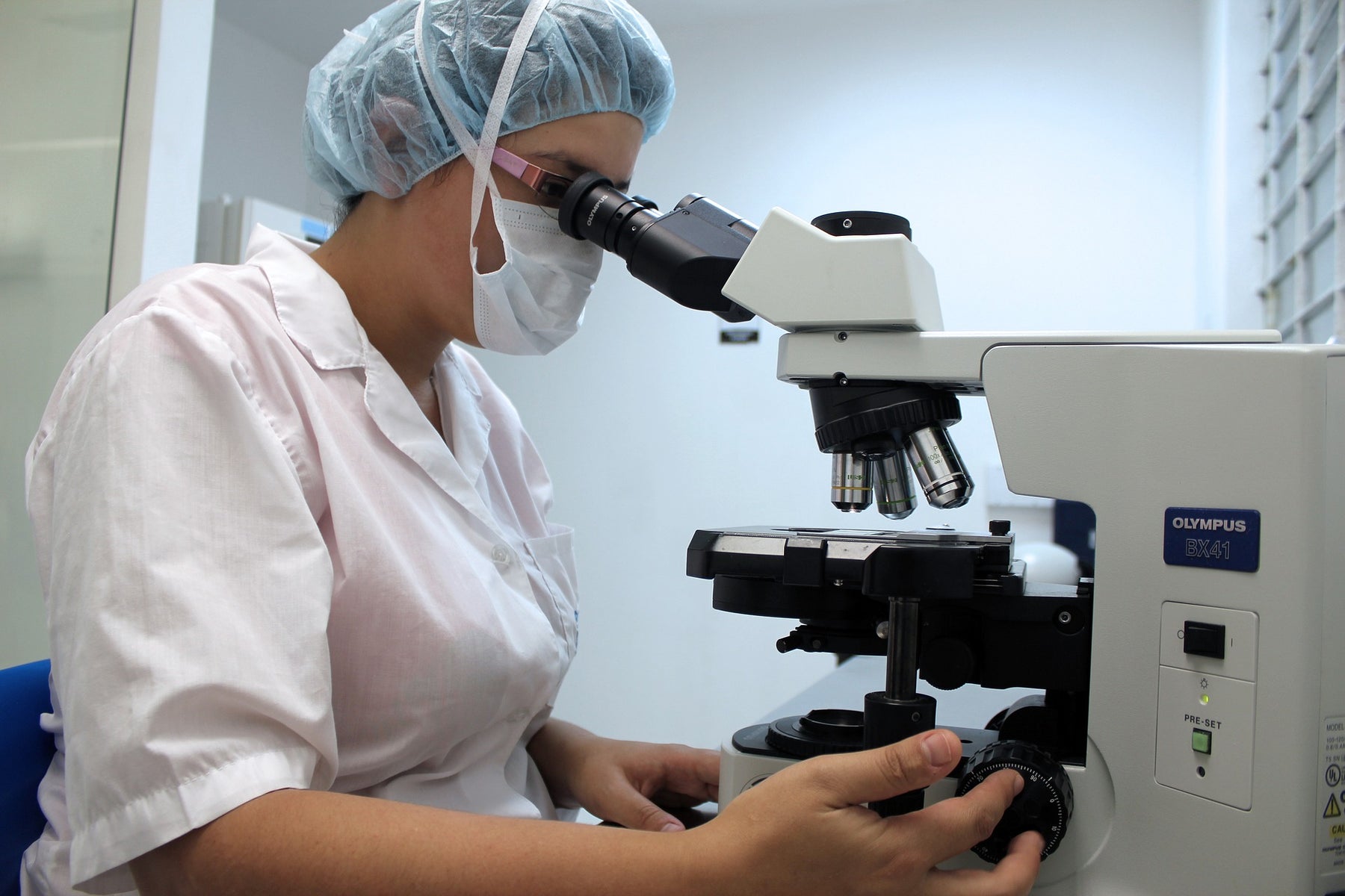 Laboratory woman looking through a microscope