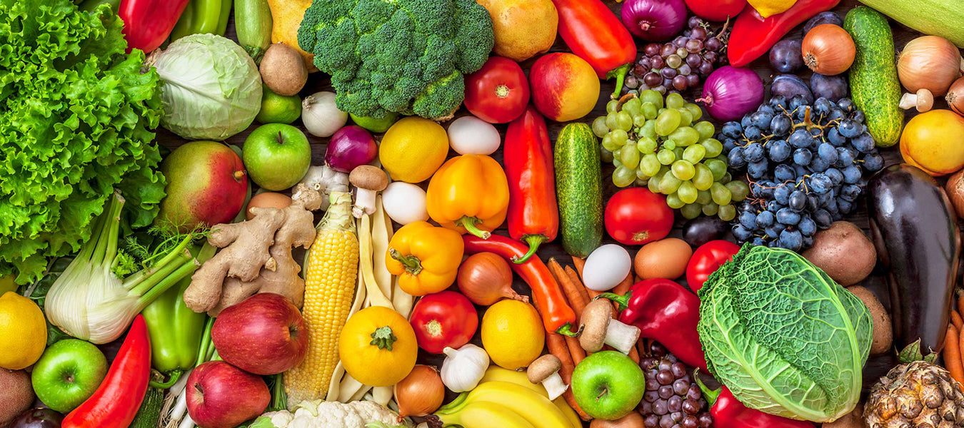 Place full of fruits and vegetables including yellow peppers, apples and onions