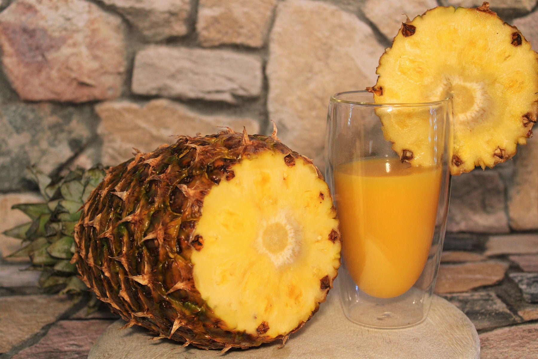 Cut pineapple along with a glass of pineapple juice