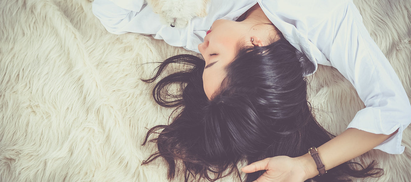 Brunette woman laying on a soft surface sleeping