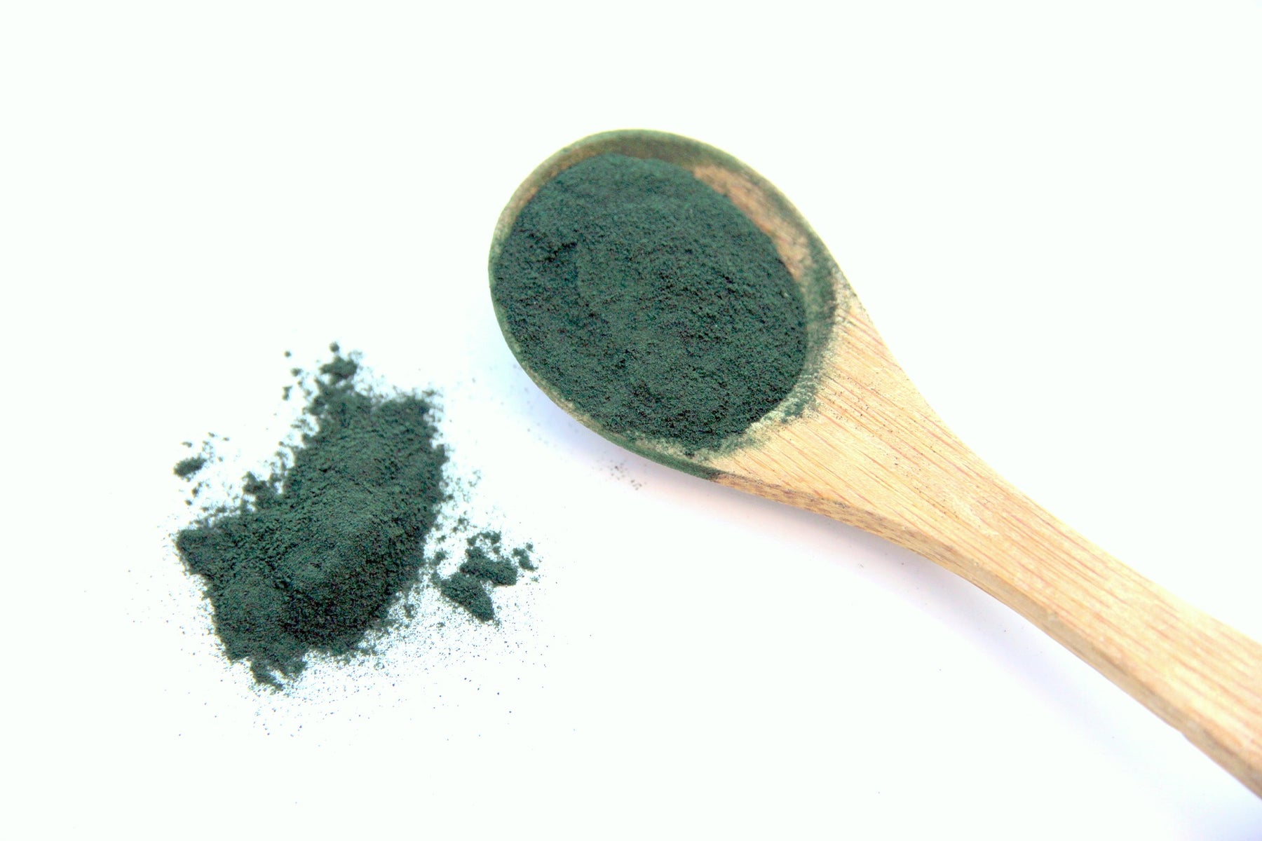 Green spirulina on a wooden spoon