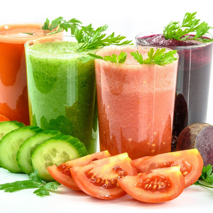 Multiple glasses of vegetable smoothie in red, green, pink and purple