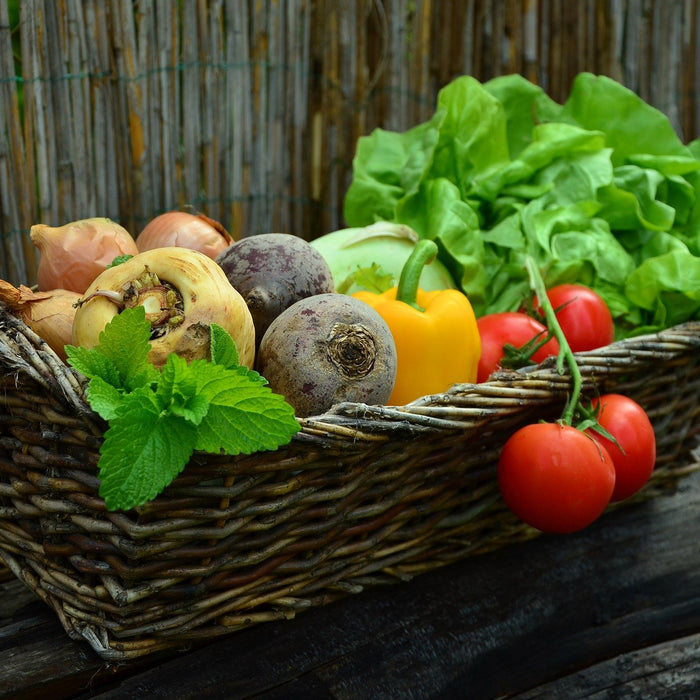 Basket full of vegetables, including tomato and bell papers