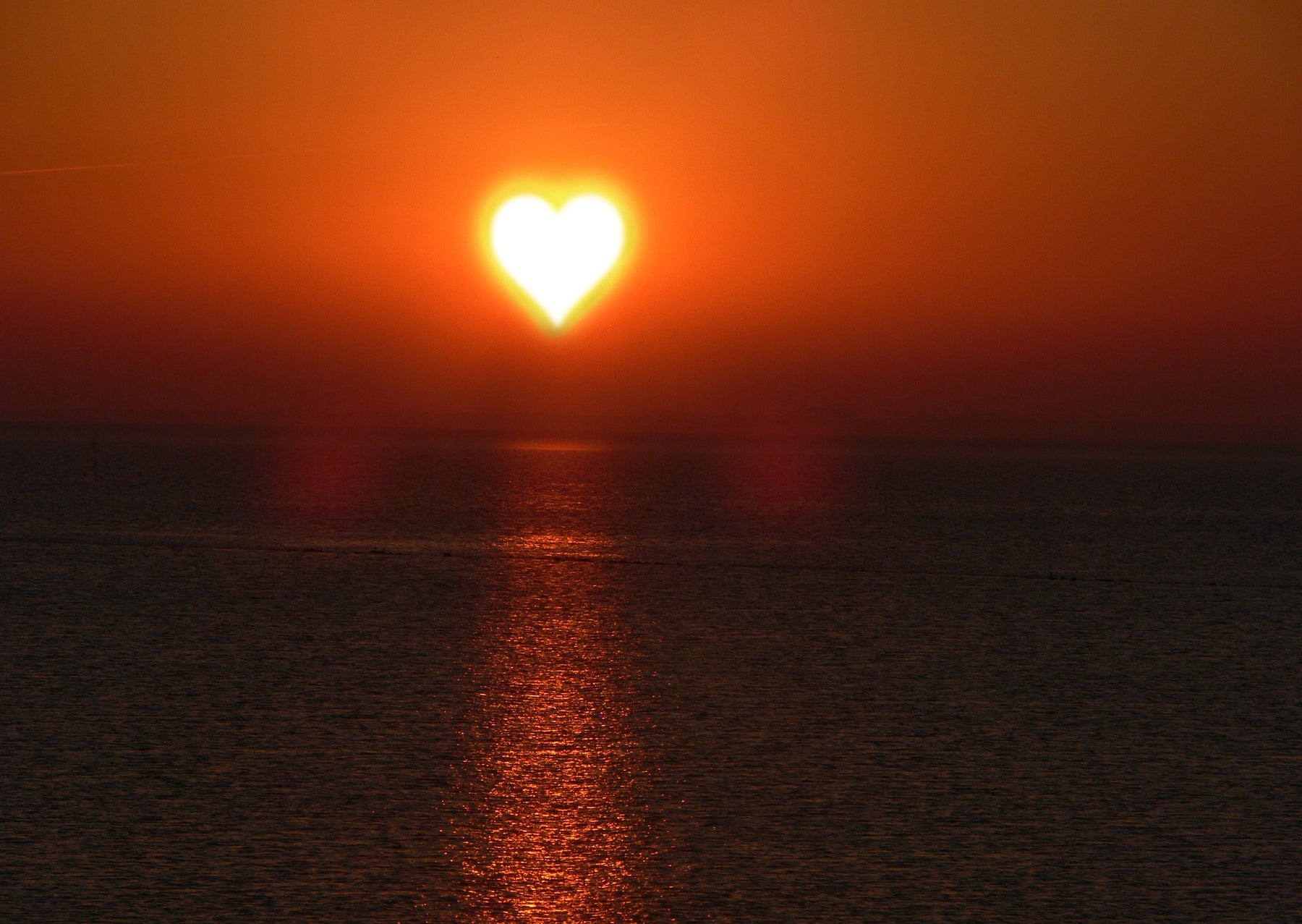 Beautiful ocean sunset with the sun shaped like a heart
