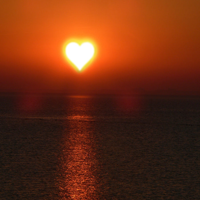 Beautiful ocean sunset with the sun shaped like a heart
