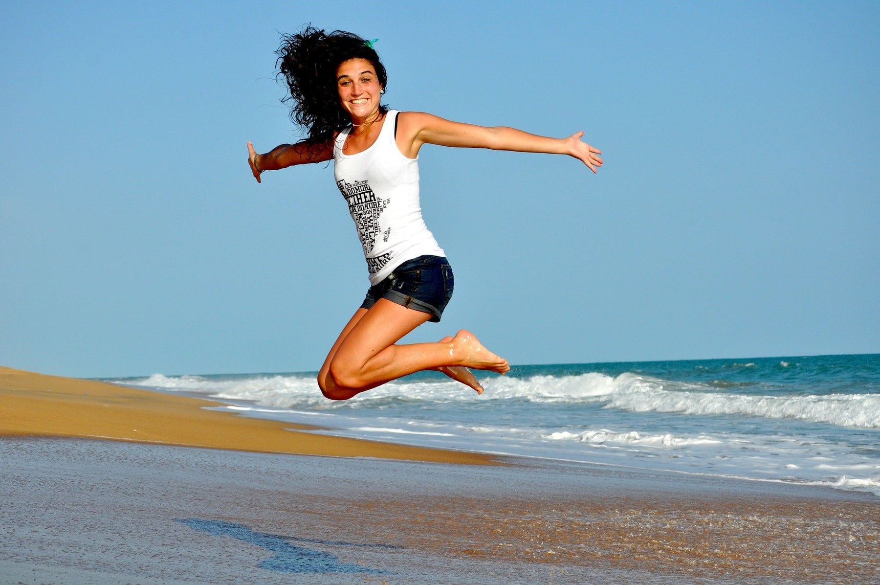 Happy woman jumping over a beach