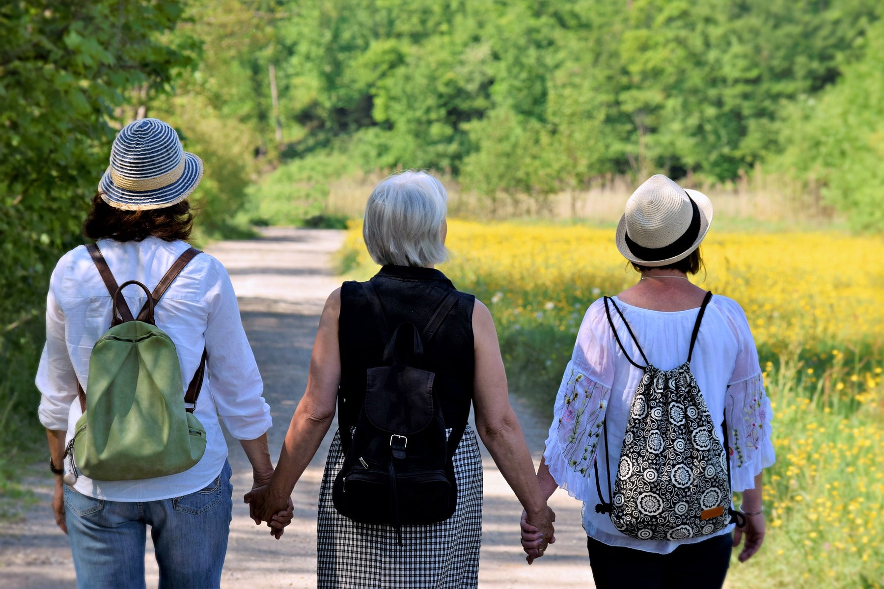 Three women walking and holding hands