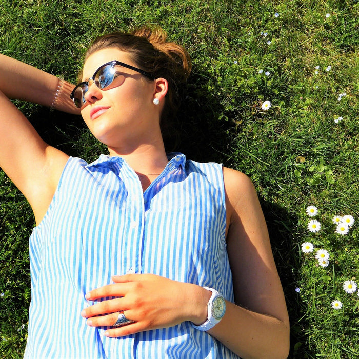 Young woman relaxing on grass wearing sun glasses